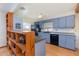 Kitchen with blue cabinets, black appliances, and hardwood floors at 224 Pennsylvania Ave, St Cloud, FL 34769
