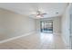 Spacious living room featuring a sliding glass door, ceiling fan, and ceramic tile flooring at 2305 St Marteen Ct # 2305, Kissimmee, FL 34741