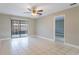 Spacious living room featuring a sliding glass door, ceiling fan, and ceramic tile flooring at 2305 St Marteen Ct # 2305, Kissimmee, FL 34741