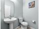 A well-maintained powder room with a pedestal sink and coastal decor at 283 Willow View Dr, Davenport, FL 33896