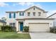 Charming two-story home with a two car garage, turquoise shutters and door at 283 Willow View Dr, Davenport, FL 33896