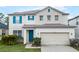 Charming home featuring a blue front door and shutters, complemented by a two-car garage at 283 Willow View Dr, Davenport, FL 33896