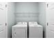 Functional laundry room with a washer, dryer, and wire shelving for storage at 283 Willow View Dr, Davenport, FL 33896