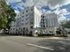 View of the condo building from the street, featuring architectural arches and lush landscaping at 304 E South St # 5020, Orlando, FL 32801