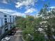 Exterior shot of the condo showcasing architectural arches and balconies overlooking the parking lot, trees, and city at 304 E South St # 5020, Orlando, FL 32801