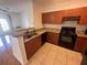 Bright kitchen features wooden cabinets, granite countertops, and modern black appliances at 304 E South St # 5020, Orlando, FL 32801