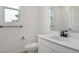 Elegant bathroom featuring a vanity with a sink, toilet, and black hardware against white walls at 306 Alexandrite St, Deland, FL 32720
