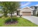 Inviting single-story home boasts a well-manicured lawn and a neutral color palette at 306 Alexandrite St, Deland, FL 32720