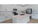 Modern kitchen featuring white cabinetry, an island, stainless steel appliances, and tile floors at 306 Alexandrite St, Deland, FL 32720