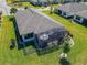 Aerial view of the house showcasing screened in lanai, well-manicured lawn, and meticulously maintained landscaping at 307 Bella Cortina Dr, Kissimmee, FL 34759