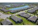 Wide aerial view of the community featuring multiple homes, lush landscaping and a tranquil lake at 307 Bella Cortina Dr, Kissimmee, FL 34759