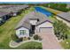 Beautiful house with lush landscaping, a brick driveway, and a water view at 307 Bella Cortina Dr, Kissimmee, FL 34759