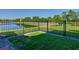 Well-maintained backyard with lush green grass, black metal fence, and scenic view of lake at 307 Bella Cortina Dr, Kissimmee, FL 34759