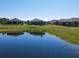 Picturesque backyard view of the lake, lush landscaping, and well-maintained lawns, creating a tranquil outdoor setting at 307 Bella Cortina Dr, Kissimmee, FL 34759
