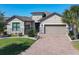 Charming one-story home with a brick driveway, a two-car garage, and a well manicured lawn at 307 Bella Cortina Dr, Kissimmee, FL 34759