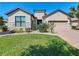 Well-maintained home featuring stone accents, a brick driveway, and a lush, green lawn at 307 Bella Cortina Dr, Kissimmee, FL 34759