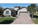 Charming home featuring stone accents, a brick driveway, and a well-manicured lawn at 307 Bella Cortina Dr, Kissimmee, FL 34759