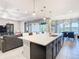 Spacious kitchen island with quartz countertops and modern light fixtures overlooking the living area at 307 Bella Cortina Dr, Kissimmee, FL 34759