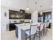 Modern kitchen with sleek dark cabinets, large island with seating, and stylish pendant lighting at 307 Bella Cortina Dr, Kissimmee, FL 34759