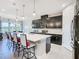 Modern kitchen features dark cabinetry, a quartz countertop island, and barstool seating at 307 Bella Cortina Dr, Kissimmee, FL 34759