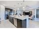 Open kitchen with island seating, stainless steel appliances, and seamless flow into the living area at 307 Bella Cortina Dr, Kissimmee, FL 34759