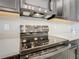 Close-up of a modern black range top with stainless steel appliances and white tiled backsplash at 307 Bella Cortina Dr, Kissimmee, FL 34759