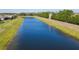 Scenic view of a pond with a distant tower and lush greenery, surrounded by a secure fence at 307 Bella Cortina Dr, Kissimmee, FL 34759