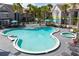 An aerial view of the community pool with lounge chairs and tropical landscaping at 3100 Parkway Blvd # 113, Kissimmee, FL 34747