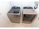 A modern laundry room with side-by-side Samsung washer and dryer units and tiled flooring at 3173 Armstrong Spring Dr, Kissimmee, FL 34744
