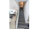 Modern staircase with wooden steps, a glass railing, and open access to the kitchen at 3173 Armstrong Spring Dr, Kissimmee, FL 34744
