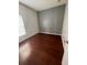 Bright bedroom features wood flooring and one window with blinds for natural light, offering a cozy retreat at 322 Ashburton Way, Kissimmee, FL 34758