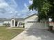 Charming single-story home with well-maintained lawn, two car garage, and beautiful landscaping at 322 Ashburton Way, Kissimmee, FL 34758