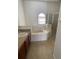Well-lit main bathroom with a soaking tub, shower, vanity and tiled flooring at 322 Ashburton Way, Kissimmee, FL 34758