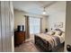 Carpeted bedroom with dresser, television, a ceiling fan and a metal framed bed with lots of pillows at 333 Almansa St, Davenport, FL 33837