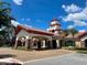 View of the clubhouse entrance featuring covered parking, decorative landscaping, and a tile roof at 333 Almansa St, Davenport, FL 33837