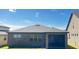 Rear exterior view showing the screen patio and back yard of the home at 333 Almansa St, Davenport, FL 33837