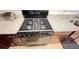 Close-up of a modern stainless steel gas range with granite countertops and dark wood cabinets at 333 Almansa St, Davenport, FL 33837
