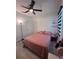 Bright bedroom featuring a ceiling fan and a comfortable bed with pink bedding and light gray wood-look flooring at 377 Holly Berry Dr, Davenport, FL 33897