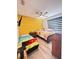 Cozy bedroom featuring two twin beds, a ceiling fan, and a textured yellow accent wall at 377 Holly Berry Dr, Davenport, FL 33897