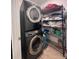 Functional laundry area featuring a stacked washer and dryer unit with metal shelving at 377 Holly Berry Dr, Davenport, FL 33897