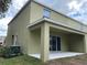 Exterior of the home with a covered patio, sliding glass doors, and lush greenery at 4247 Shackelford Ct, Orlando, FL 32824