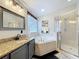 Bright primary bathroom features granite counters, double sinks, walk-in shower and separate tub at 4907 Raylene Way, St Cloud, FL 34771