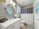 Well-lit bathroom with a marble vanity, oval mirror, and a modern black and white shower curtain at 4907 Raylene Way, St Cloud, FL 34771