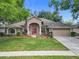Beautiful single-story home featuring well-manicured lawn, tasteful landscaping, and a charming red front door at 4907 Raylene Way, St Cloud, FL 34771