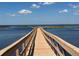 Picturesque view of a wooden pier leading to the serene water, perfect for fishing and enjoying lake life at 4907 Raylene Way, St Cloud, FL 34771