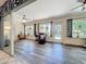 Bright sunroom with wood-look tile flooring and large windows with black and white checked curtains at 4907 Raylene Way, St Cloud, FL 34771