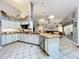 Open kitchen featuring white cabinets, granite counters, an island and views to the living room at 4907 Raylene Way, St Cloud, FL 34771