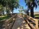 Scenic wooden walkway surrounded by trees leads to stunning lake views and outdoor enjoyment at 4907 Raylene Way, St Cloud, FL 34771