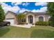 Inviting home featuring stone accents, a well-kept lawn, and a welcoming front entrance at 4910 Culdesac Ct St, St Cloud, FL 34772