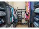 This walk-in closet has a tile floor, metal shelving on both sides, and hanging clothes at 4910 Culdesac Ct St, St Cloud, FL 34772